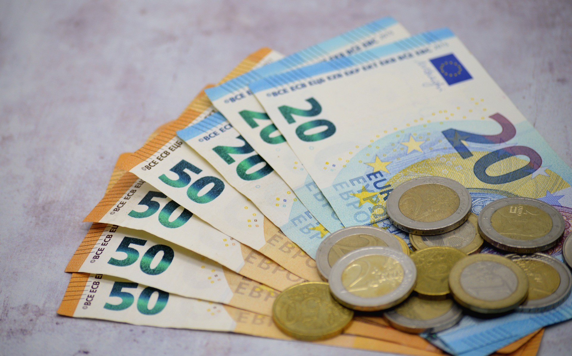 Euroseteleitä ja -kolikoita pöydällä